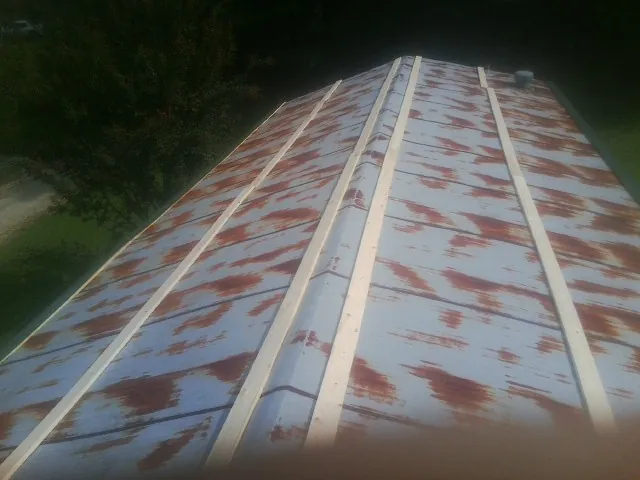 Rusted metal roof panels with new wood purlins before replacement — Storm Damage Roof Repair in Hinsdale by Roofing Brothers