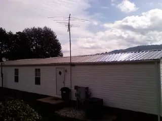New metal roof on a single wide mobile home with a TV antenna in Hinsdale